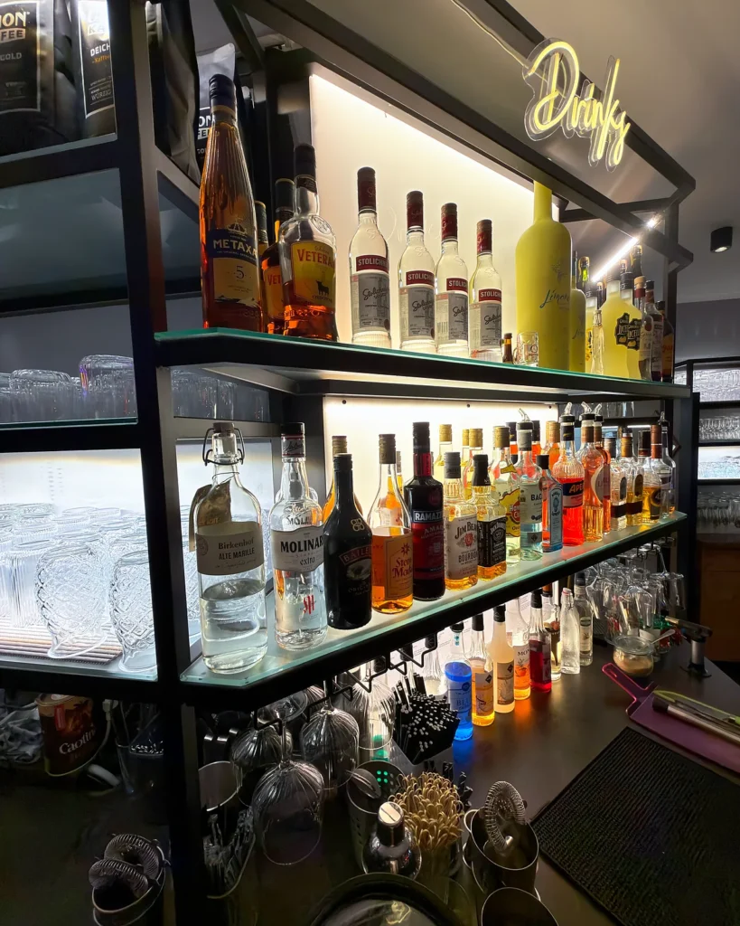 Beleuchtetes Spirituosenregal mit Neon-Schriftzug an der MIRA Bar