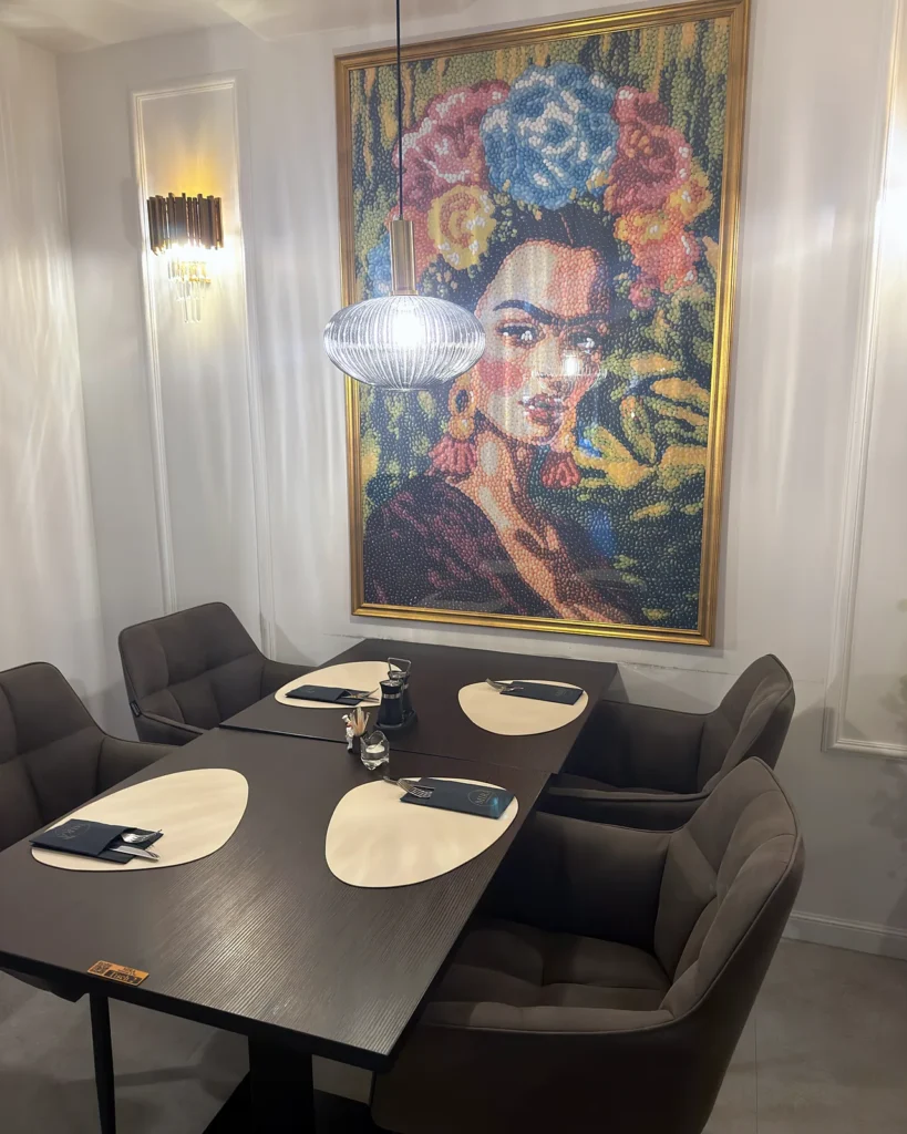 Gedeckter Tisch vor großem Frida-Kunstwerk im MIRA